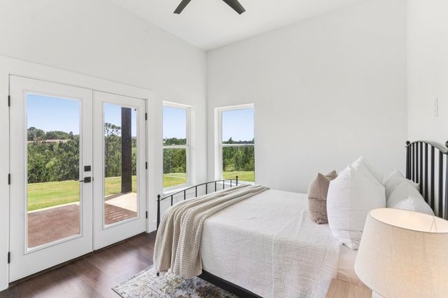 Bedroom with access to outside, multiple windows, wood finished floors, and ceiling fan | Image 17