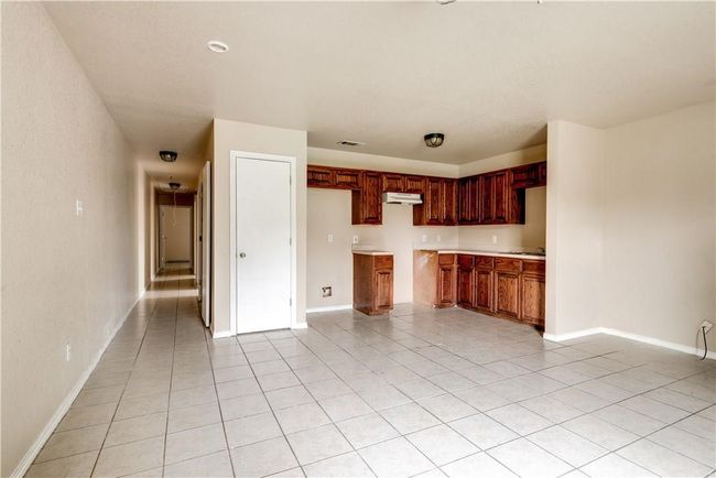 Kitchen featuring light tile patterned floors, light countertops, and under cabinet range hood | Image 10