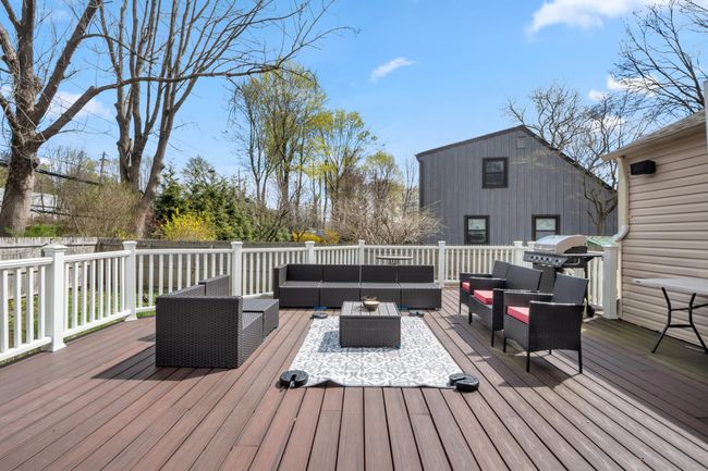 Wooden terrace featuring outdoor lounge area and a grill | Image 9