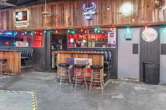 Indoor dry bar with concrete flooring and wooden walls | Image 13