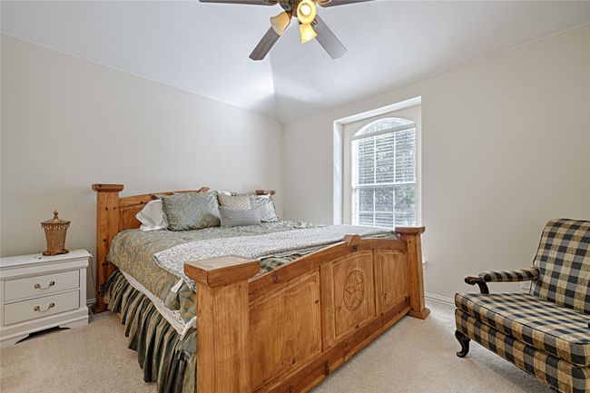 Bedroom featuring light carpet, ceiling fan, baseboards, and vaulted ceiling | Image 19