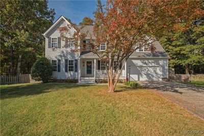 View of front of home featuring a porch, a front yard, and a garage | Image 2