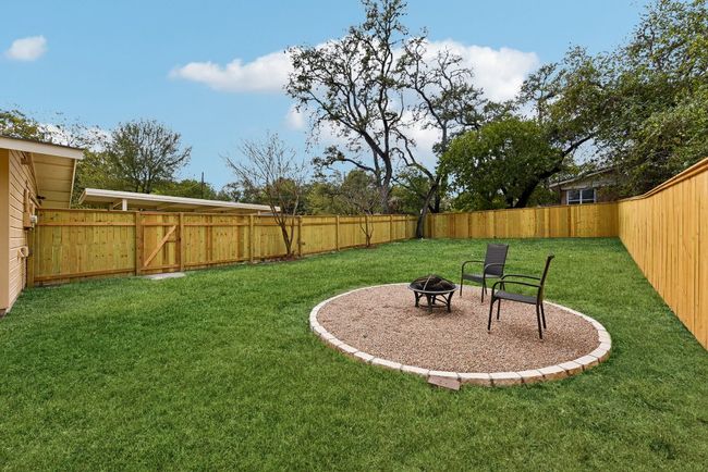 View of yard with a fenced backyard and an outdoor fire pit | Image 6