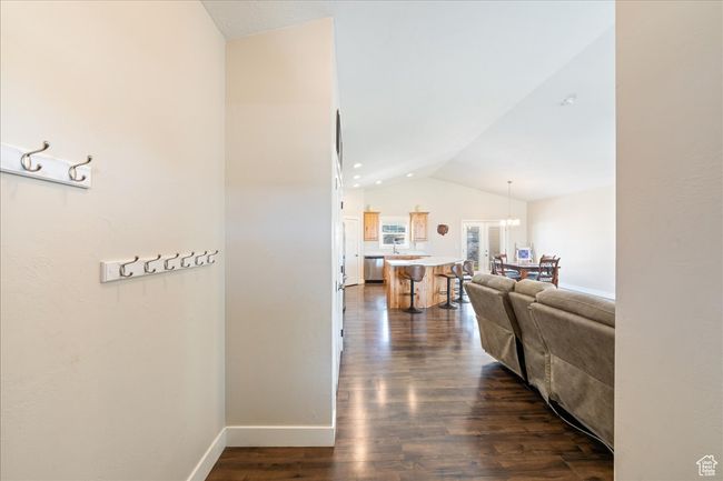 Hallway with vaulted ceiling, baseboards, and dark wood-type flooring | Image 8