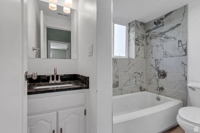 Full bathroom with visible vents, toilet, vanity, and shower / bathing tub combination | Image 19