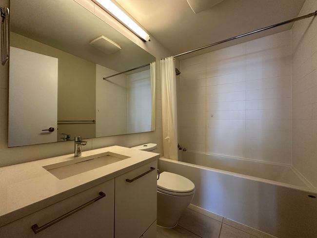 Full bathroom featuring tile patterned flooring, shower / tub combo with curtain, toilet, and vanity | Image 16