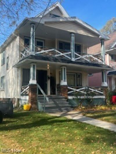 Rear view of property with a lawn, a balcony, and covered porch | Image 1