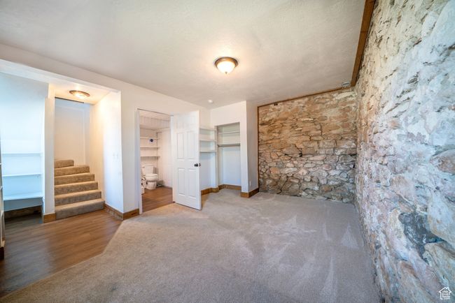 Unfurnished bedroom with carpet flooring, a textured ceiling, baseboards, and ensuite bathroom | Image 12