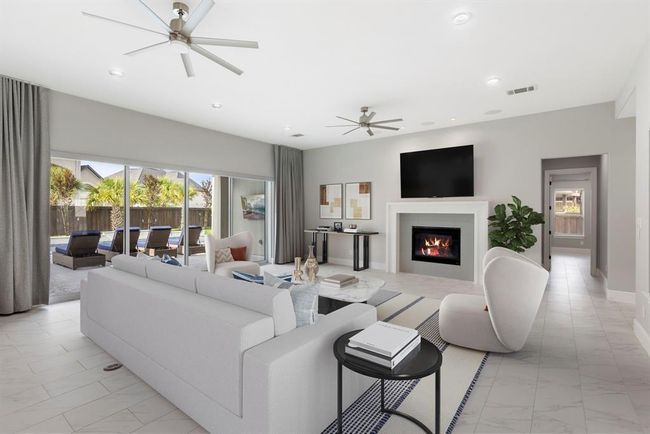 This chic living room features expansive glass sliders and sleek custom electronic drapes, offering effortless control of natural light and a seamless connection to expand living space into the outdoors. *This photo has been virtually staged.* | Image 13