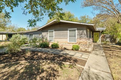 Nestled under a canopy of trees, this home embodies a calming nature atmosphere. | Image 3