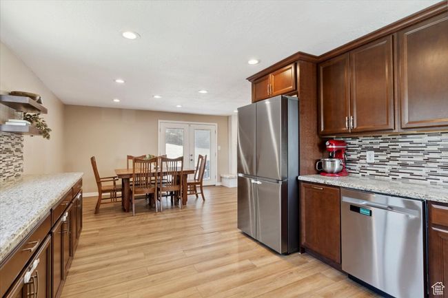 Kitchen with appliances with stainless steel finishes, granite countertops, wood LVP floors, recessed lighting, windows and backsplash | Image 11