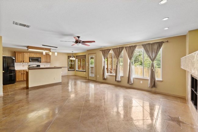 Unfurnished living room with ceiling fan, recessed lighting, a fireplace, and a textured ceiling | Image 6
