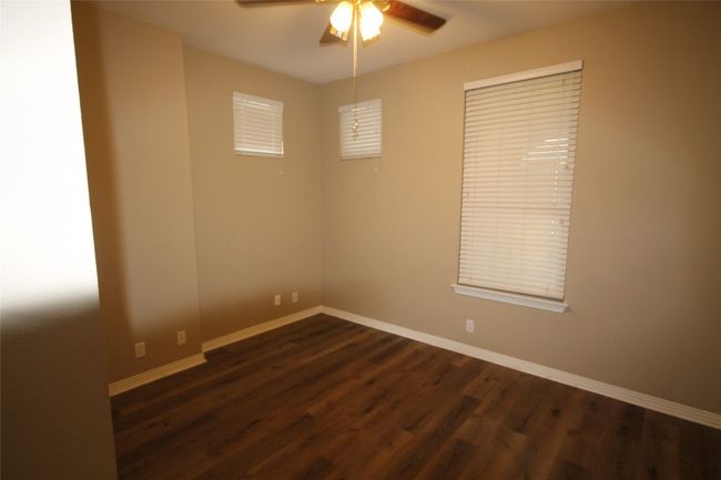 Empty room featuring a ceiling fan and dark wood-style floors | Image 8