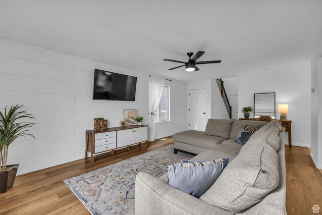 Living area featuring new wood finished floors, shiplap feature wall, updated paint and lighting | Image 11