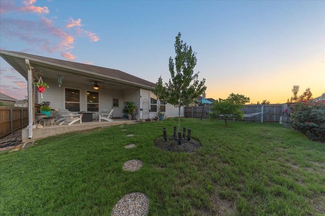 Fenced backyard with a patio area and a ceiling fan | Image 17