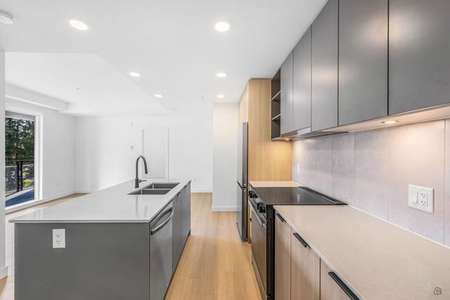 Kitchen featuring a sink, an island with sink, decorative backsplash, stainless steel appliances, and modern cabinets | Image 9