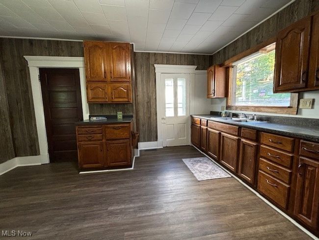 Kitchen featuring wood walls, sink, and dark wood-type flooring | Image 9