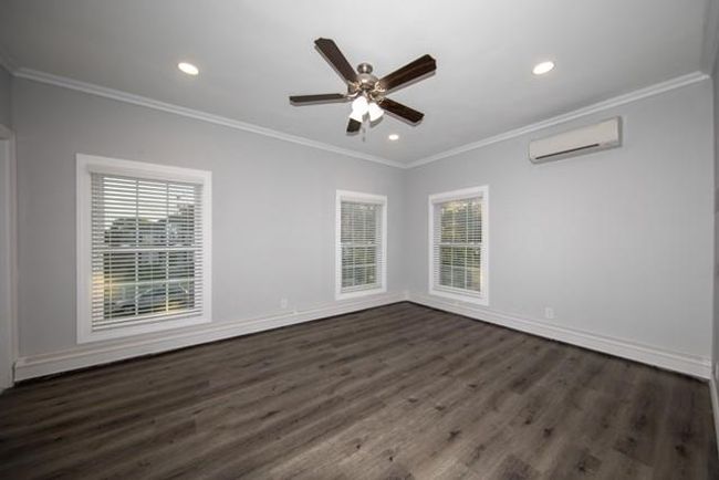 Unfurnished room with ornamental molding, dark wood finished floors, ceiling fan, an AC wall unit, and recessed lighting | Image 4