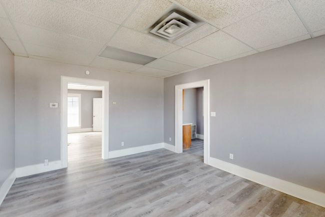 Spare room featuring light wood-type flooring and a paneled ceiling | Image 12