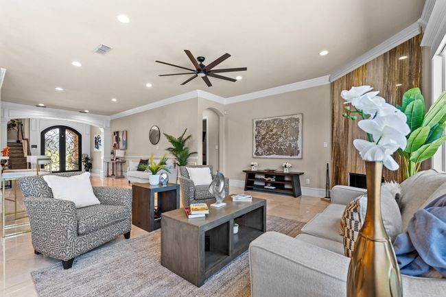 Living area with arched walkways, recessed lighting, crown molding, a ceiling fan, and light tile patterned floors | Image 11