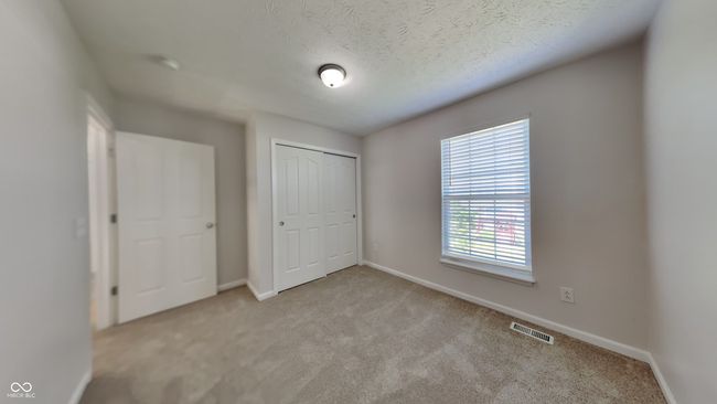 unfurnished bedroom featuring light colored carpet, baseboards, a closet, and a textured ceiling | Image 13