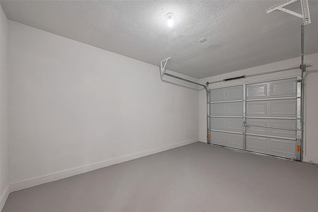 A look inside the one-car attached garage reveals a clean, well-maintained space perfect for storage or a workshop setup. | Image 26