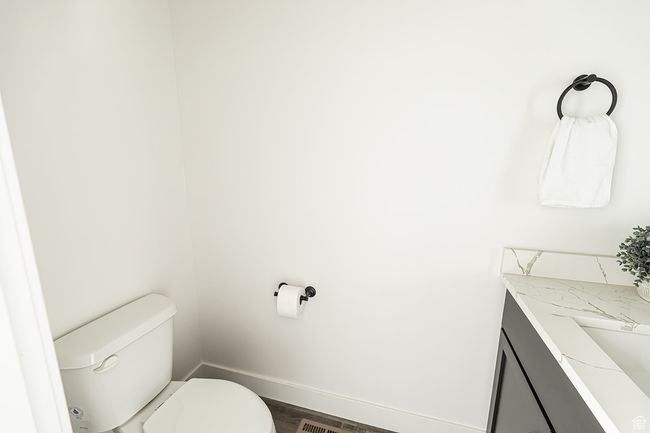 Half bath featuring baseboards, wood finished floors, toilet, and vanity | Image 18