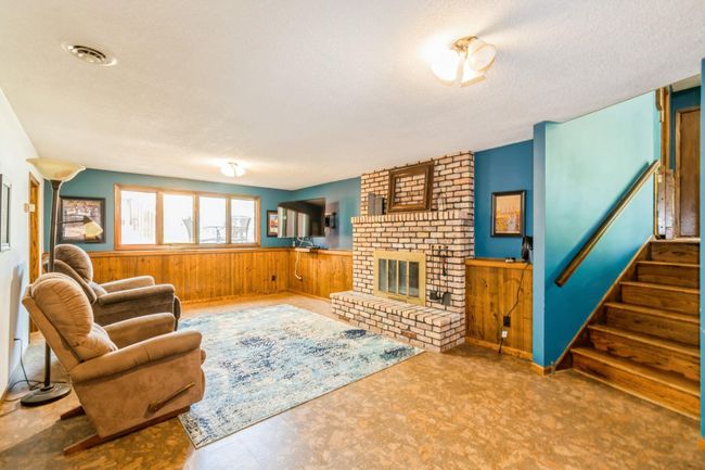 Lower level family room has a wood burning fireplace. | Image 39