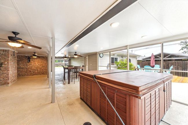 Screened covered patio w/lighting, ceiling fans and hot tub | Image 23