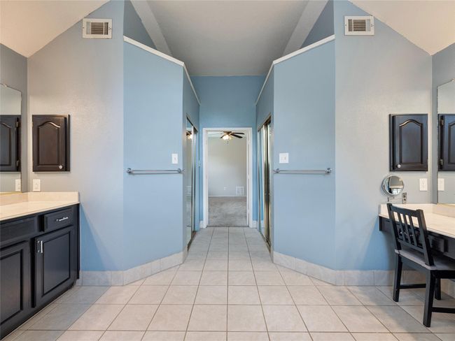 Bathroom with lofted ceiling, a ceiling fan, vanity, and tile patterned floors | Image 17
