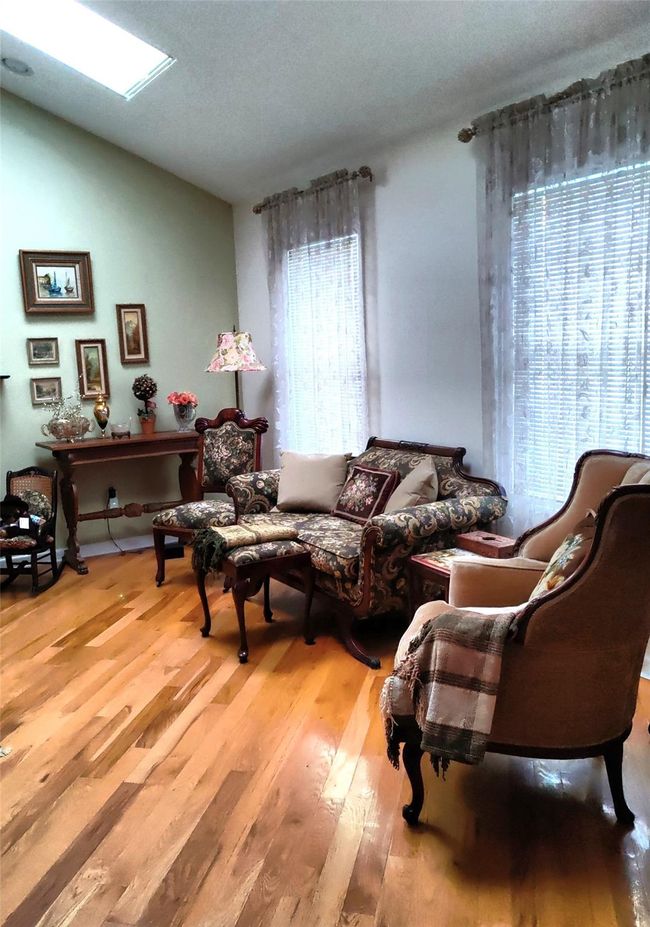 Sitting room featuring plenty of natural light, wood finished floors, and vaulted ceiling | Image 22