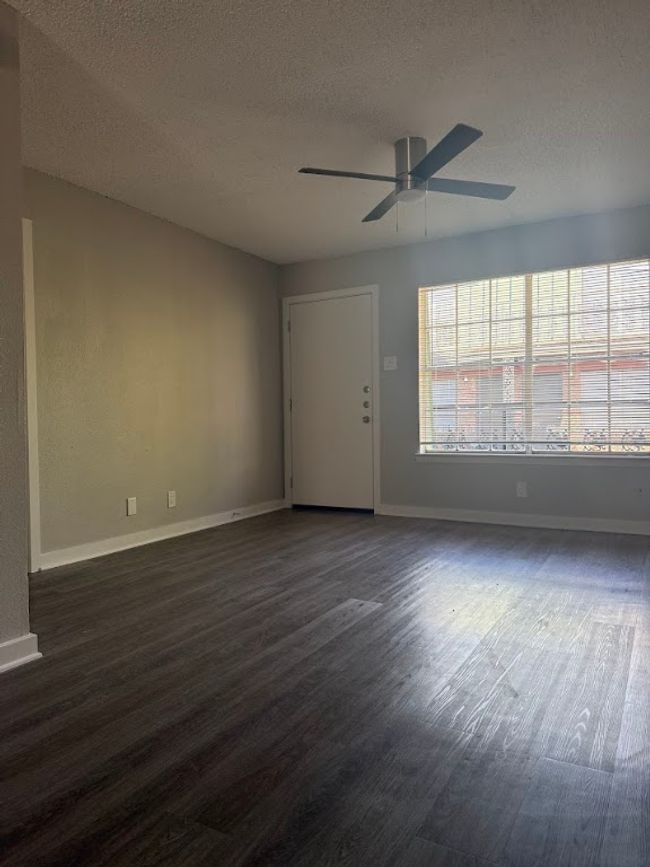 Spare room featuring a textured ceiling, ceiling fan, dark wood-style flooring, and baseboards | Image 5