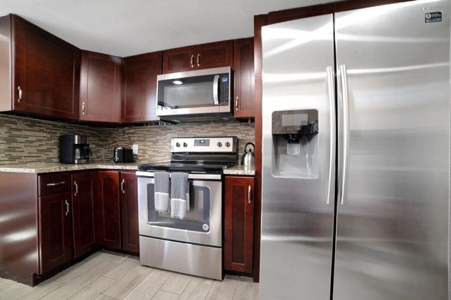 Kitchen with stainless steel appliances, granite countertops, laundry room and recessed lighting | Image 9