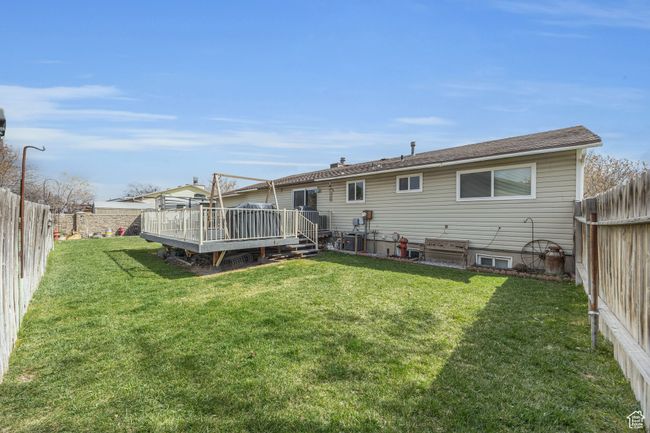 Back of house featuring a fenced backyard, a deck, and a yard | Image 22