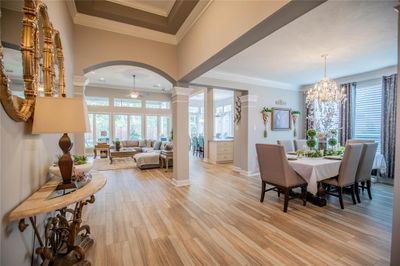 Discover Elegance: This stunning open-concept space, featuring an exquisite dining area and a cozy living room, is bathed in natural light. Elegant finishes and a serene color palette create an inviting atmosphere that awaits your personal touch. | Image 1