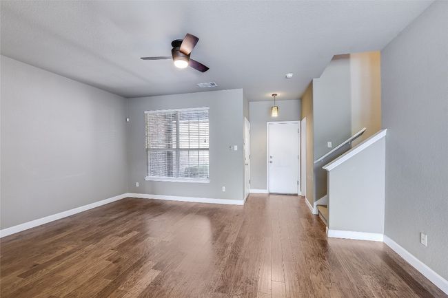 Foyer entrance featuring wood finished floors, ceiling fan, baseboards, and stairs | Image 5