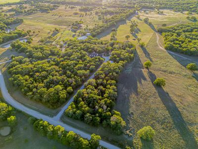 Aerial view of the entire property featuring beautiful trees and a peaceful meadow. | Image 1