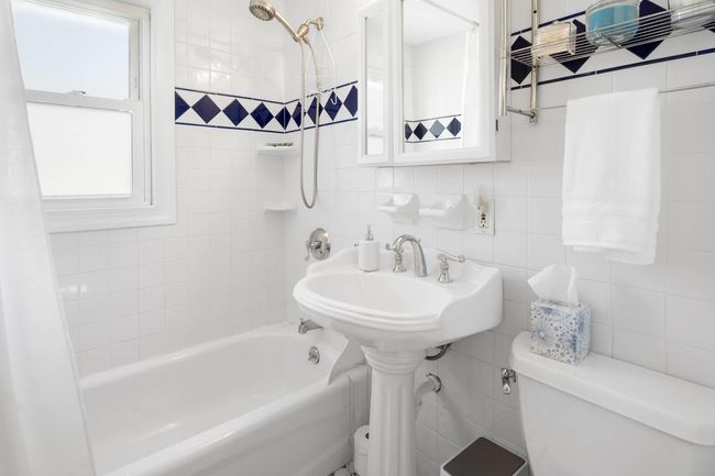 Bathroom with shower / bath combination with curtain, tasteful backsplash, toilet, and tile walls | Image 13