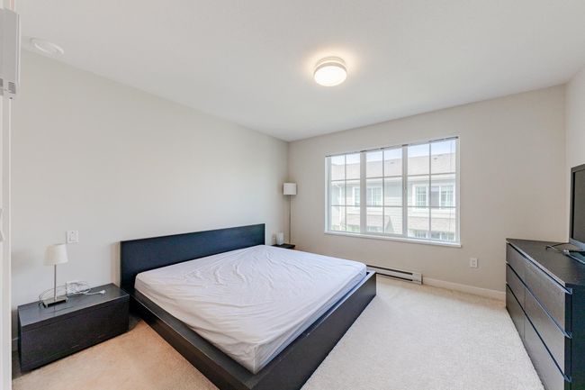 Bedroom featuring a baseboard radiator and light carpet | Image 16