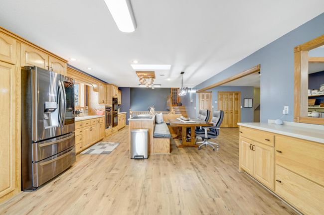 Gorgeous high end appliances include a Jennair cooktop and convenient raised dishwasher, along with tons of custom cabinets with Silestone counters. | Image 11