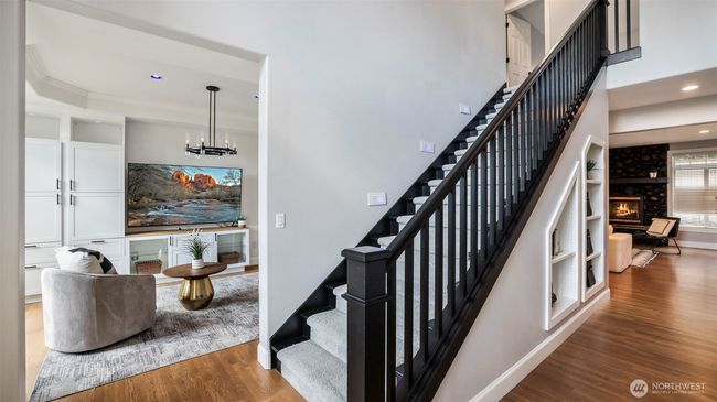 Walk into tall ceilings and a bold entry with a modern black-railed staircase and direct access to one of the home’s two spacious living areas! | Image 5
