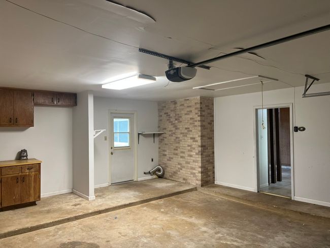 Garage with a garage door opener and baseboards | Image 13