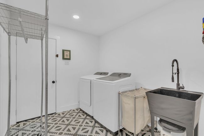 Washroom with laundry area, a sink, baseboards, separate washer and dryer, and recessed lighting | Image 33