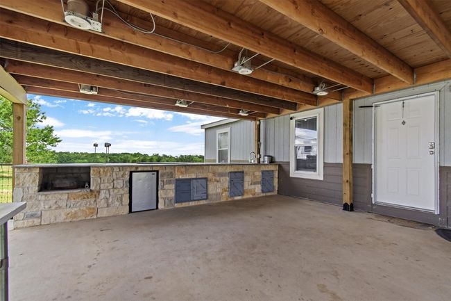 The centerpiece is a spacious 2, 061 sq ft manufactured home, just 1.5 years old, with 4 bedrooms, 2 bathrooms, and a beautifully crafted 40' x 20' stone outdoor kitchen under a covered roof with lighting—ideal for hosting under the stars. | Image 17