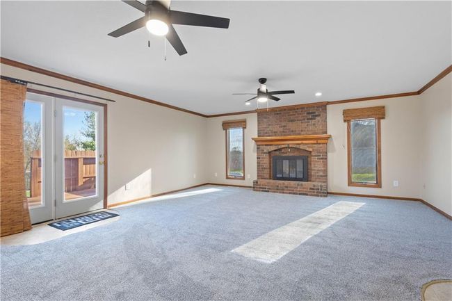 Unfurnished living room featuring carpet flooring, a fireplace, baseboards, ceiling fan, and recessed lighting | Image 33