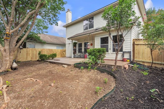 View of the back of the home, a small portion of the patio is covered, broken portions of the fence have been replaced, trees have been trimmed, we simply didn't have the money to replace the grass in the back, roof replaced May of 2025 | Image 25
