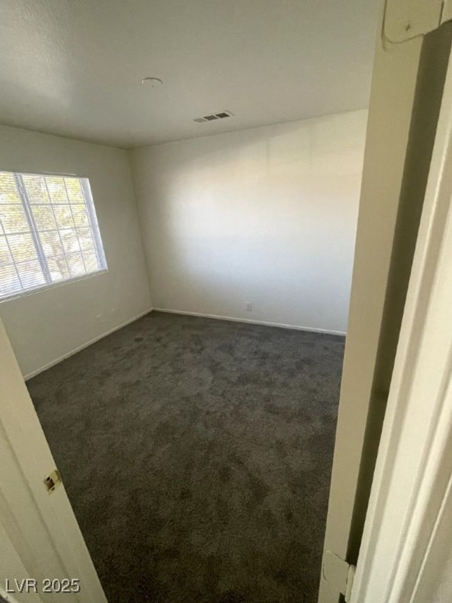 Empty room featuring baseboards, visible vents, and dark carpet | Image 16