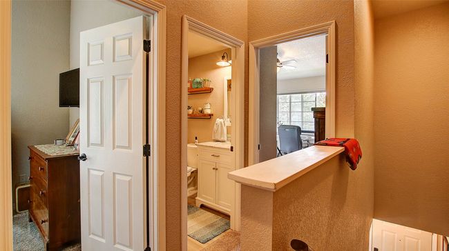 Office area featuring a textured wall and a ceiling fan | Image 24