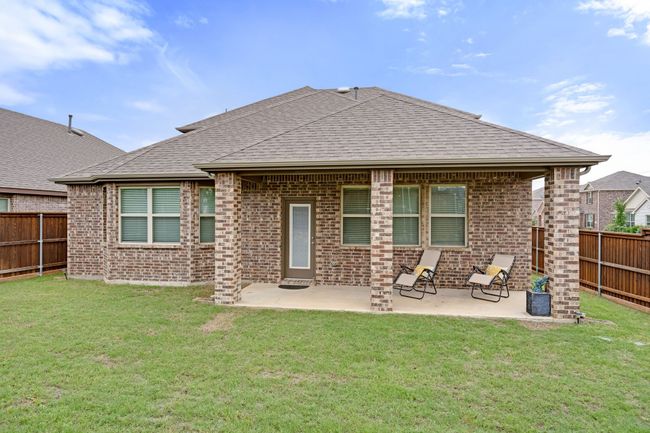 Back of property with brick siding, a Covered patio, and a shingled roof | Image 33