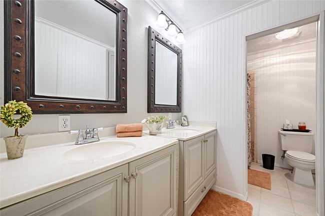 Bathroom featuring tile patterned flooring, crown molding, wood walls, toilet, and vanity | Image 29